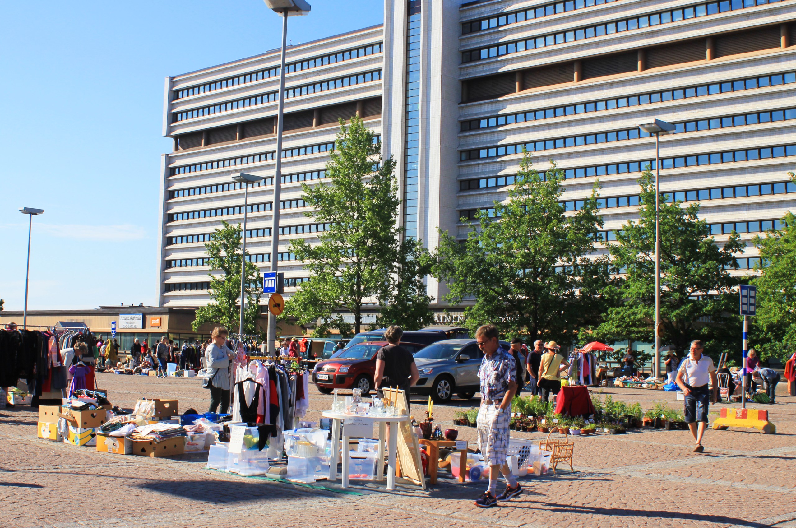 Pohjola-Torin kirpputorilla ihmisiä ostoksilla kesäpäivänä