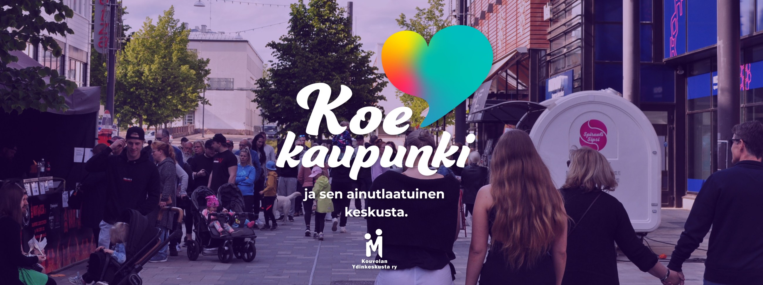 Koe kaupunki logokuva ja teksti violettisävyisen Kävelykatu Manskin yleisökuvan päällä.
